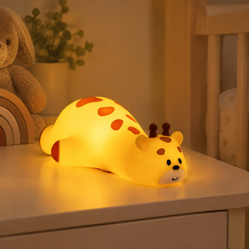 Veilleuse girafe en silicone allongée et allumée dans une chambre d'enfant