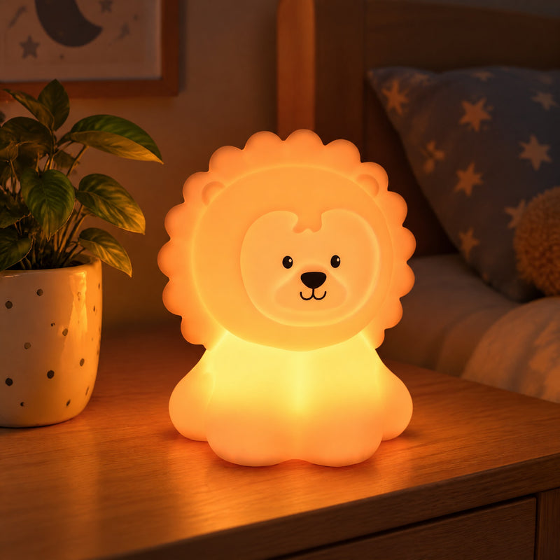 Veilleuse lion en silicone allumée en orange sur une table de chevet