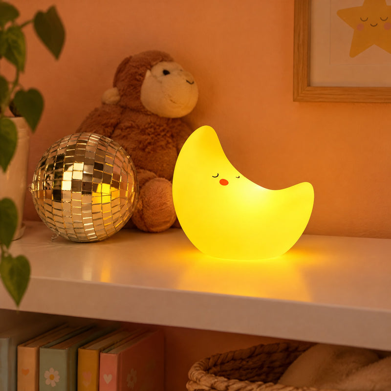 Veilleuse lune enfant jaune au visage endormi posée sur une étagère de chambre