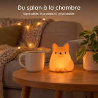 Veilleuse renard orange allumée sur une table basse de salon, à côté d'une tasse, sans câble